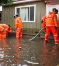 Orange County Fire Authority firefighters work to pump out flood waters from a home in Santa Ana, Calif., Wednesday, Jan. 6, 2016. El Nino storms lined up in the Pacific, promising to drench parts of the West for more than two weeks and increasing fears of mudslides and flash floods in regions stripped bare by wildfires. (Leonard Ortiz/The Orange County Register via AP)