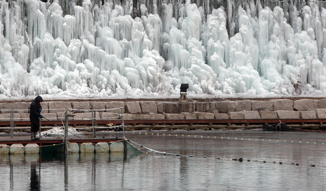 A man fishes with a lure at the Hwacheon Sancheoneo (mountain trout) Ice Festival in Gangwon Province, Jan. 13. Seven dramas and shows produced by television stations from Malaysia, the Philippines, Thailand, Indonesia, Vietnam, Hong Kong and Singapore will feature various winter attractions in Korea including the winter festival through February. (Yonhap)