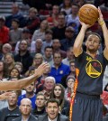 Golden State Warriors guard Stephen Curry, right, shoots over Portland Trail Blazers guard C.J. McCollum, left, during the first half of an NBA basketball game in Portland, Ore., Friday, Feb. 19, 2016. (AP Photo/Craig Mitchelldyer)