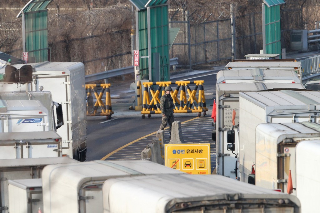 South Korean cargo trucks wait to head to the North Korean city of Kaesong as a South Korean Army patrols at the customs, immigration and quarantine office near the border village of Panmunjom in Paju, South Korea, Thursday, Feb. 11, 2016. South Korea said Wednesday that it will shut down a joint industrial park with North Korea in response to its recent rocket launch, accusing the North of using hard currency from the park to develop its nuclear and missile programs. (AP Photo/Ahn Young-joon)