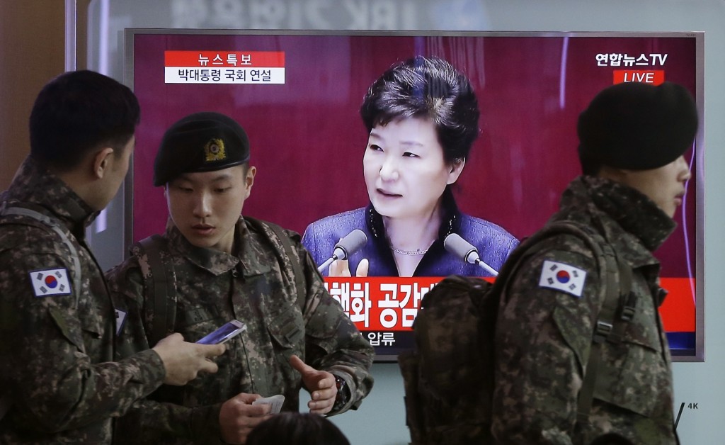South Korean army soldiers pass by a TV screen showing the live broadcast of South Korean President Park Geun-hye's speech, at the Seoul Railway Station in Seoul, South Korea, Tuesday, Feb. 16, 2016. President Park warns of North Korean collapse if it doesn't abandon its nuclear program. (AP Photo/Ahn Young-joon)