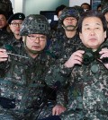 Saenuri Party Chairman Kim Moo-sung, right, listens to the commander of the 6th Infantry Division during his visit to a general post near the border in Cheorwon County, Monday. (Joint press corps)