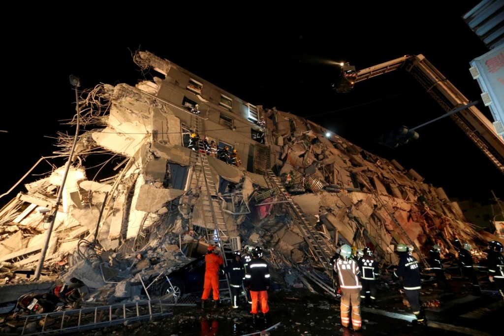 Rescue workers search a toppled building after an earthquake in Tainan, Taiwan, Saturday, Feb. 6, 2016. The 6.4-magnitude earthquake struck southern Taiwan early Saturday, toppling at least one high-rise residential building and trapping people inside. Firefighters rushed to pull out survivors. (AP Photo) 