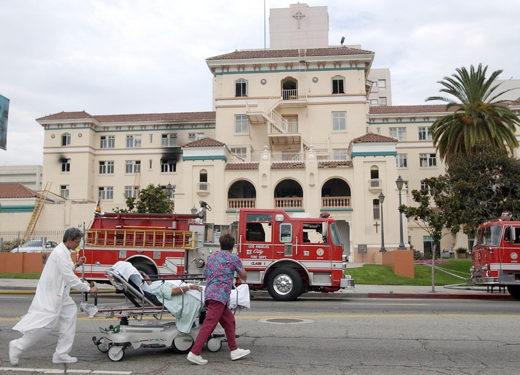 FILE - In this July 22, 2003, file photo, nurses evacuate a patient after a fire broke out on the third floor of the 434-bed the formerly named Queen of Angels-Hollywood Presbyterian Medical Center, with visibly blackened windows, in the Hollywood section of Los Angeles. The FBI says Wednesday, Feb. 17, 2016, it is investigating a computer network extortion plot at the Los Angeles hospital. In the attacks known as "ransomware," hackers lock up an institution's computer network and demand payment to reopen them. FBI spokeswoman Laura Eimiller said Wednesday that the agency is investigating such a plot at the Hollywood Presbyterian Medical Center. (AP Photo/Nick Ut, File)