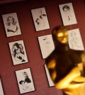 A sample of over 160 caricatures of Hollywood figures created for the Academy Awards Governors Ball are displayed behind an Oscar statue at the 88th Academy Awards Governors Ball Press Preview on Thursday, Feb. 18, 2016, in Los Angeles. The 88th Academy Awards ceremony will be held at the Dolby Theatre in Los Angeles on Sunday, Feb. 28. (Photo by Chris Pizzello/Invision/AP)
