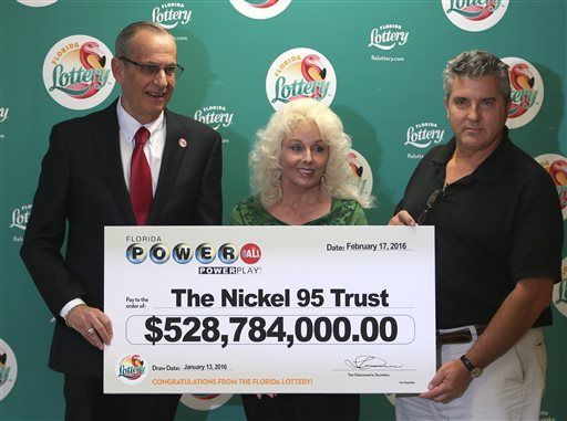 Florida Lottery Secretary Tom Delacenserie, left, presents Maureen Smith and David Kaltschmidt with their one-third share of the Jan. 13, world record Powerball jackpot Wednesday, Feb. 17, 2016, in Tallahassee, Fla. John and Lisa Robertson of Munford, Tenn., cashed in their ticket last month, also taking the lump sum. The winners in California have not publicly come forward yet. (AP Photo/Steve Cannon)