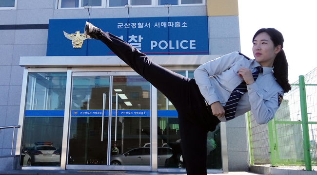 Kim Seung-hee, a former national taekwondo champion turned police officer, demonstrates a side kick in front of her office in Gunsan, North Jeolla Province, Thursday. (Yonhap)