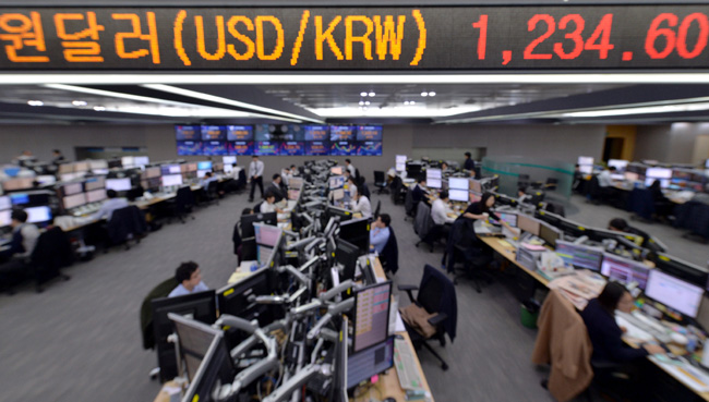 Foreign exchange dealers watch monitors at KEB Hana Bank in Seoul, Friday, when the won extended its decline to close at 1,234.4 won against the U.S. dollar, the lowest level since June 11, 2010. The Bank of Korea said Friday it will take every measure to prevent the won from fluctuating further against the dollar. (Korea Times photo by Seo Jae-hoon)