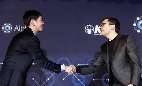South Korean Go player Lee Se-dol (L) shakes hands with Google DeepMind CEO Demis Hassabis at their post-match press conference at Four Seasons Hotel in Seoul on March 15, 2016. Lee played Go matches against AlphaGo, an artificial intelligence program developed by Google DeepMind. (Yonhap).