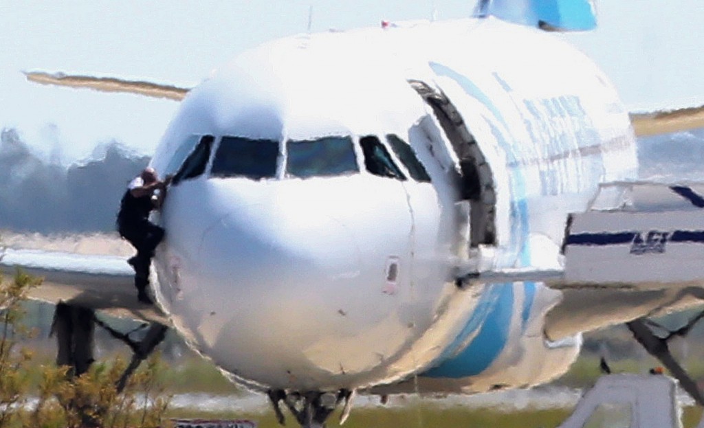 A man, leaves the hijacked aircraft of Egyptair from the pilot's window after landing at Larnaca airport Tuesday, March 29, 2016. An EgyptAir plane was hijacked  while flying from the Egyptian Mediterranean coastal city of Alexandria to the capital, Cairo, and later landed in Cyprus where some of the women and children were allowed to get off the aircraft, according to Egyptian and Cypriot officials. (AP Photo/Petros Karadjias)