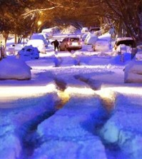 A person works to dig out a vehicle stuck in the middle of Jennings Street in Sioux City, Iowa's, north side early Thursday morning, March 24, 2016. A spring snow storm dropped about 14-inches of snow in Sioux City according to the National Weather Service. (Tim Hynds/Sioux City Journal via AP)