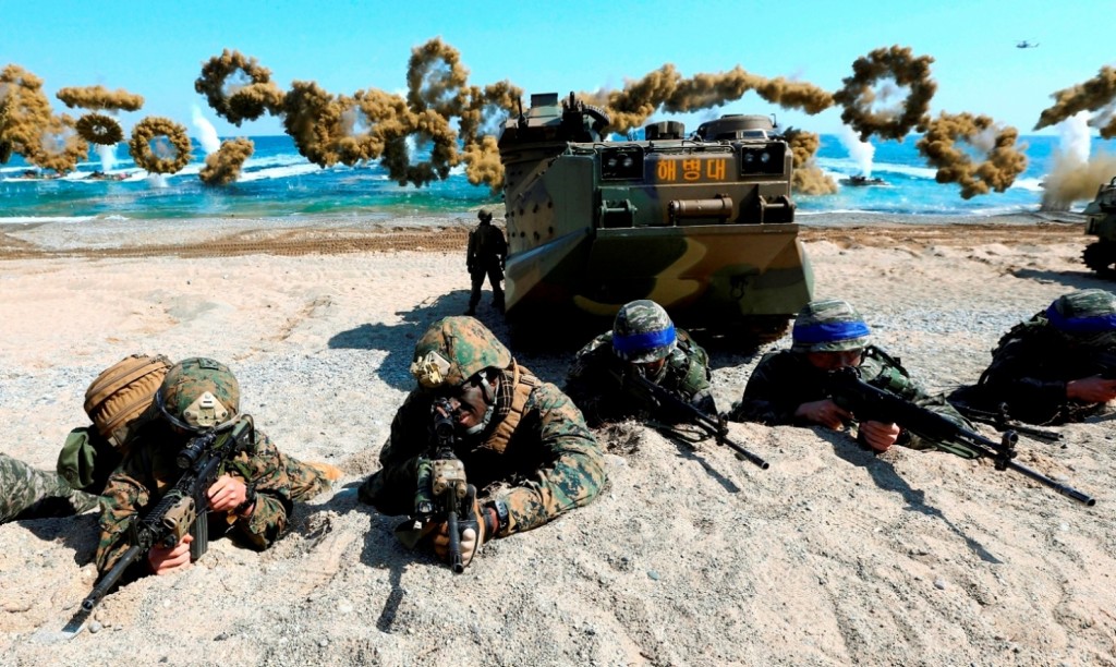 FILE - In this March 12, 2016 file photo, U.S. Marines, left, and South Korean Marines, wearing blue headbands on their helmets, take positions after landing on the beach during the joint military combined amphibious exercise, called Ssangyong, part of the Key Resolve and Foal Eagle military exercises, in Pohang, South Korea. It’s a demand North Korea has been making for decades: The U.S. and South Korea must immediately suspend their annual military exercises if they want peace on the Korean Peninsula. And, once again, it’s a demand that is falling on deaf ears. This year’s exercises are bigger than ever before and reportedly include training to take out Kim Jong Un himself. For Pyongyang’s ruling regime, that’s a bridge too far. But probably not far enough to fire the first shots over. (Kim Jun-bum/Yonhap via AP, File)