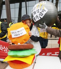 Members of the Arbeit Workers Union, representing part-time workers, stage a performance urging McDonald's Korea to scrap its "45 second rule" on making burgers, among other demands, in front of the fast food chain's office in Gwanghwamun, downtown Seoul, Monday. The union called for a collective bargaining session with the company on the issues. (Yonhap)