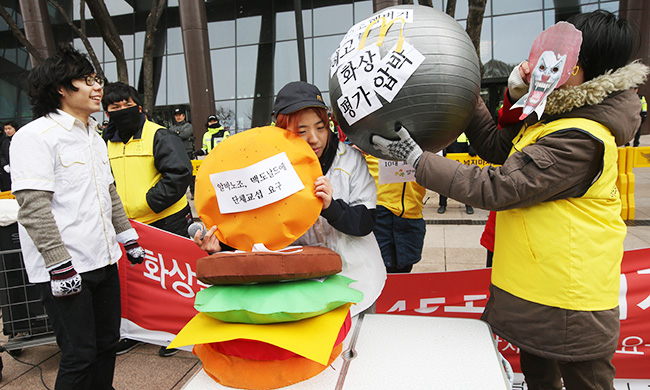 Members of the Arbeit Workers Union, representing part-time workers, stage a performance urging McDonald's Korea to scrap its "45 second rule" on making burgers, among other demands, in front of the fast food chain's office in Gwanghwamun, downtown Seoul, Monday. The union called for a collective bargaining session with the company on the issues. (Yonhap)