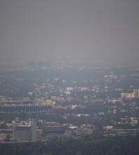 Mexico City's Azteca Stadium, left, is seen through a thick haze, Tuesday, March 15, 2016. The Mexico City government declared its first air pollution alert in 11 years Monday, after ozone levels reached almost twice the acceptable limit. (AP Photo/Eduardo Verdugo)