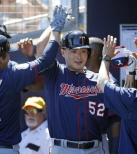 Minnesota Twins' Byung Ho Park, center, of South Korea, high-fives teammates in the dugout after hitting a grand slam in the first inning of a spring training baseball game against the Tampa Bay Rays in Port Charlotte, Fla., Sunday, March 6, 2016. (AP Photo/Patrick Semansky)