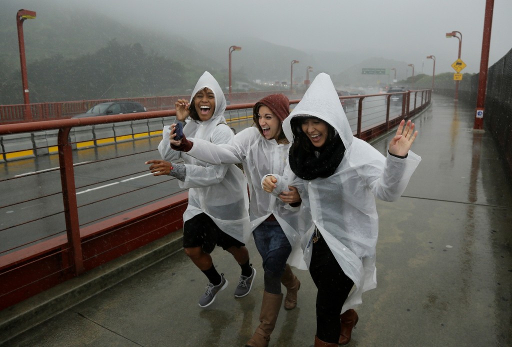 Three women run and laugh in the rain as they begin to cross the Golden Gate Bridge Thursday, March 10, 2016, in Sausalito, Calif. The ongoing deluge of storms in Northern California has swelled lakes and dams, boosting the prospects for outdoor recreation but likely falling short of ending the drought. Heavy rain hit the region north of San Francisco on Thursday with four inches expected by Friday, the National Weather Service said.(AP Photo/Eric Risberg) 