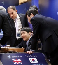 South Korean professional Go player Lee Sedol smiles as he reviews the match with other Go players after finishing the final match of the Google DeepMind Challenge Match against Google's artificial intelligence program, AlphaGo, in Seoul, South Korea, Tuesday, March 15, 2016. Google's Go-playing computer program again defeated its human opponent in the final match on Tuesday that sealed its 4:1 victory. (AP Photo/Lee Jin-man)