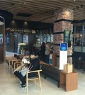 Two customers talk to each other while waiting to handle their financial transactions in a Woori Bank outlet which opened a 'cafe in branch' in Yongsan, central Seoul, on March 28, 2016 in this photo provided by the bank. (Yonhap)