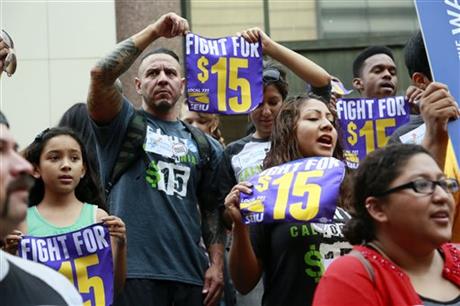 FILE - In this Tuesday, July 21, 2015 file photo, workers hold a rally in Los Angeles in support of the Los Angeles County Board of Supervisors' proposed minimum wage ordinance. On Saturday, March 26, California legislators and labor unions reached an agreement that will take the state's minimum wage from $10 to $15 an hour. (AP Photo/Nick Ut)