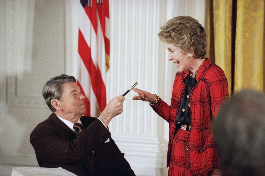 FILE - In this Nov. 18, 1988 file photo, former President Ronald Reagan hands a pen to then first lady Nancy Reagan after he signed a major anti-drug bill at a White House East Room ceremony in Washington. Reagan dedicated the bill to Nancy, who has led a "Just Say No" campaign among America's youth, and gave her the pen he used to sign the bill with. Nancy Reagan, who died Sunday, March 6, 2016, is perhaps best known for her "Just Say No" to drugs and alcohol campaign. Three decades after the campaign's heyday, prevention experts credit it with spawning a new generation of research into the best ways of reducing drug abuse. But they also say that many of the fear-based tactics it embraced didn't work.  (AP Photo/Ron Edmonds, File)