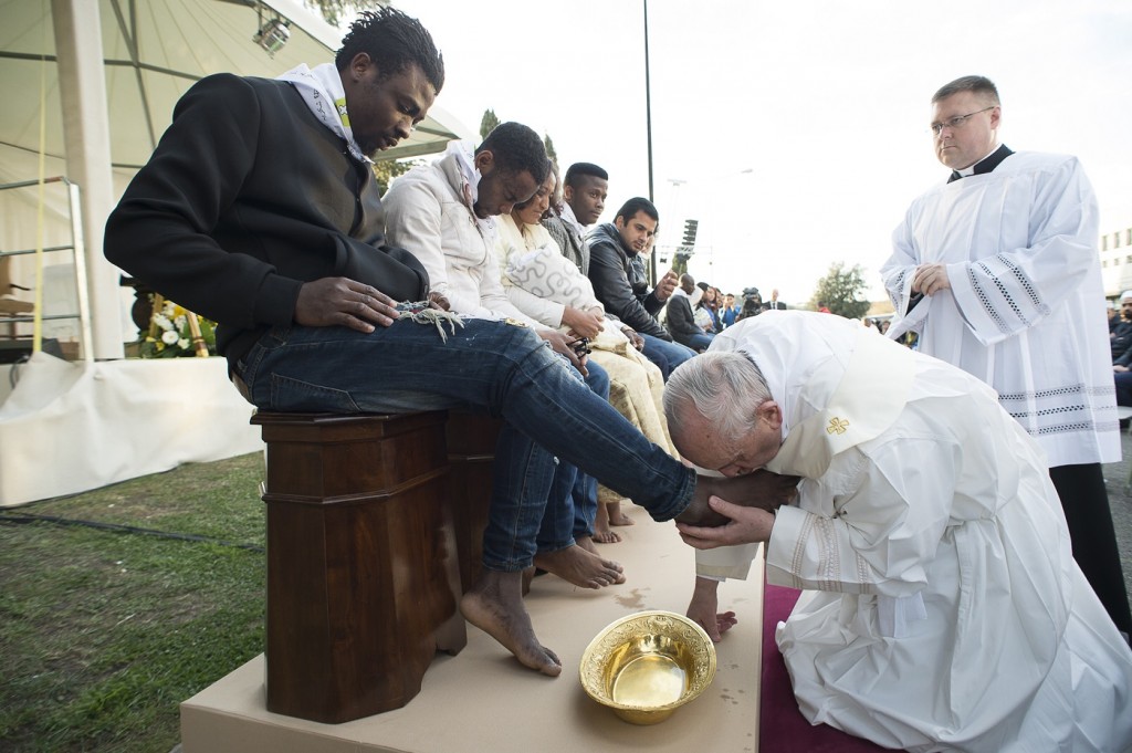 Pope Francis kisses the foot of a man during the foot-washing ritual at the Castelnuovo di Porto refugees center, some 30km (18, 6 miles) from Rome, Thursday, March 24, 2016. The pontiff washed and kissed the feet of Muslim, Orthodox, Hindu and Catholic refugees Thursday, declaring them children of the same God, in a gesture of welcome and brotherhood at a time when anti-Muslim and anti-immigrant sentiment has spiked following the Brussels attacks. (L'Osservatore Romano/Pool Photo via AP)