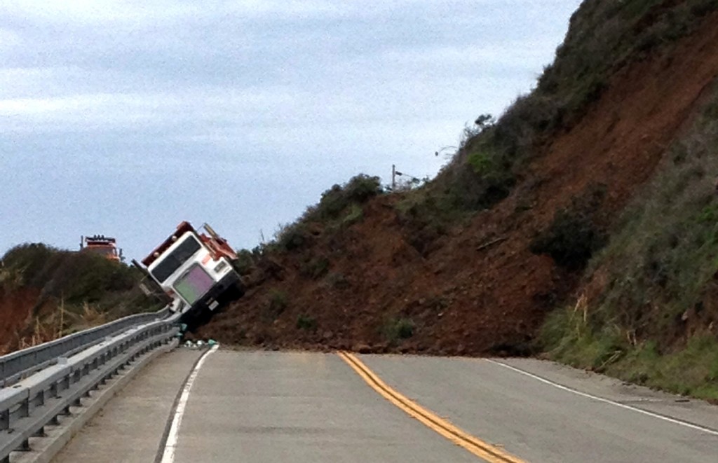 This photo provided by the California Department of Transportation shows a Caltrans dump truck that was nearly toppled by a mud slide along California Highway 1 in Mendocino County, Calif. on Friday, March 11, 2016. The highway is closed indefinitely after the overnight slides. (California Department of Transportation via AP)