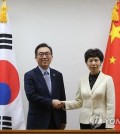 Second Vice Foreign Minister Cho Tae-yul (L) shakes hands with Chinese Vice Commerce Minister Gao Yan (R) before their talks at the foreign ministry building in Seoul on April 20, 2016.