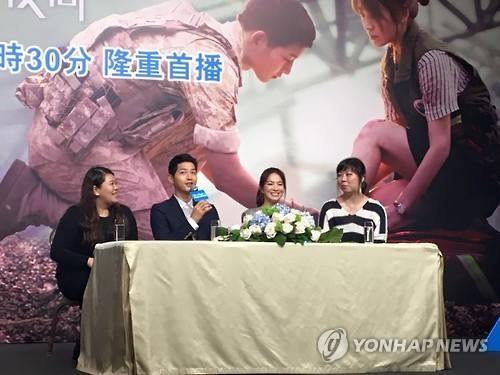 Actor Song Joong-ki (2nd from L) speaks and actress Song Hye-kyo smiles during a news conference in Hong Kong to promote the popular Korean TV series "Descendants of the Sun" on April 5, 2016.