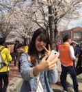 Sunday Kailing from Malaysia poses for a selfie in Seoul's main financial district of Yeouido on April 5, 2016.
