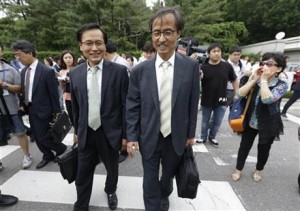 South Korean human right lawyers leave after a court hearing on the detention of North Korean defectors as an anti-North Korean protester, right, shouts to them in front of the Seoul District Court in Seoul, South Korea, Tuesday, June 21, 2016. As South Korea's main spy agency prepares a courtroom defense of its continued detention of 12 North Korean waitresses it says fled from China, Pyongyang is using the women's relatives and colleagues to step up its accusations that they were tricked into leaving their jobs and essentially kidnapped.