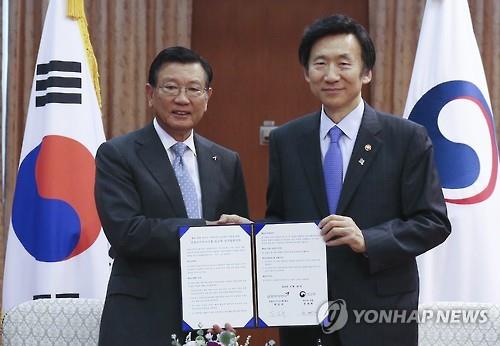 Foreign Minister Yun Byung-se (R) and Kumho Asiana Group Chairman Park Sam-koo pose for a photo after signing an agreement to speed up evacuation operations at the foreign ministry in Seoul on June 28, 2016. (Yonhap)