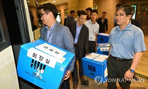 Prosecutors carry boxes of documents and computer files confiscated from Lotte Chairman Shin Dong-bin's office in Lotte Hotel in downtown Seoul on June 10, 2016. 