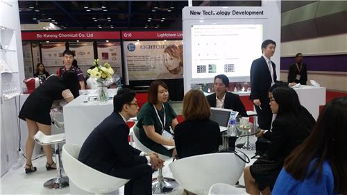 In this photo taken on July 7, 2016, a group of businesspeople are in talks for possible deals at Caregen's booth during the "in-cosmetics Korea" exhibition held at COEX hall in Seoul on July 6-7. (Yonhap)