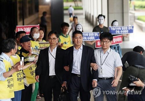 John Lee (C), former CEO of the South Korean unit of Oxy Reckitt Benckiser, appears at the Seoul Central District Prosecutors' Office in southern Seoul on May 23, 2016, to face questioning over the British firm's toxic humidifier sterilizer that has allegedly resulted in scores of deaths and illnesses here since 2011. Prosecutors said on July 14 that they have indicted the Korean American. (Yonhap)