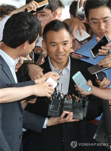 Kim Jung-ju, founder of South Korea's leading online game maker Nexon Co., is surrounded by journalists as he appears before the Seoul Central District Prosecutors' Office on July 13, 2016, to face questioning over his alleged involvement in a senior prosecutor's shady stock transactions.