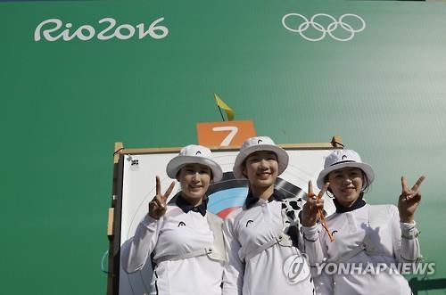 From left: South Korean archers Ki Bo-bae, Choi Mi-sun and Chang Hye-jin pose before their target after completing the ranking round at the Rio de Janeiro Olympics in this Associated Press taken on Aug. 5, 2016.
