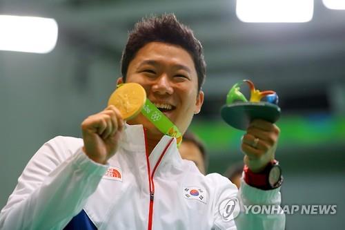South Korean shooter Jin Jong-oh holds up his gold medal from the men's 50m pistol at the Rio de Janeiro Olympics on Aug. 10, 2016.