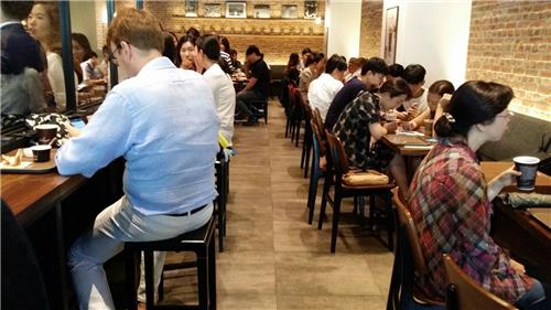 A coffee shop in central Seoul is crowded with office workers enjoying coffee after lunch on Aug. 10, 2016.