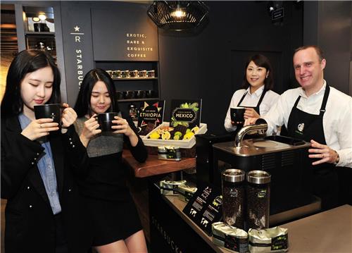 In this photo, provided by Starbucks Korea, consumers test-drink specialty coffee at a Starbucks Reserve cafe in Seoul.