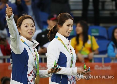 South Korean archers Chang Hye-jin (L) and Ki Bo-bae stand on the podium in the women's individual event as the gold and bronze medalist at the Rio de Janeiro Olympics on Aug. 11, 2016. 