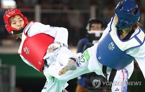South Korea's Kim So-hui (L) battles Panipak Wongpattanakit of Thailand in the quarterfinals of women's -49kg taekwondo at the Rio de Janeiro Olympics on Aug. 17, 2016. (Yonhap)