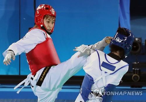 Kim So-hui of South Korea (L) lands a kick on Tijana Bogdanovic of Serbia during the final of the women's -49kg taekwondo event at the Rio de Janeiro Olympics on Aug. 17, 2016. 