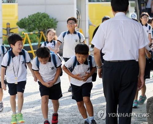 Students bow to their teacher at Shingwang Elementary School in Seoul's Yongsan Ward on Aug. 17, 2015, as they returned to school after summer vacation, which ended the previous day.