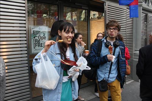 French locals enjoy boiled fish cakes and corn dogs in the Korean street food festival held in Paris on Sept. 26, 2015.