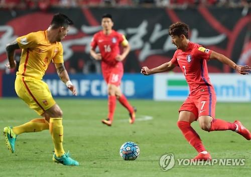 South Korean midfielder Son Heung-min (R) tries to dribble past Feng Xiaoting of China during their Asian World Cup qualifier at Seoul World Cup Stadium on Sept. 1, 2016.