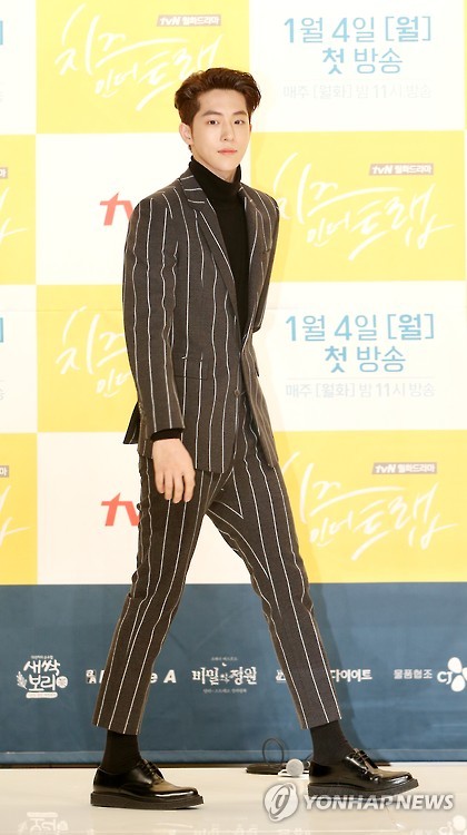 South Korean actor Nam Ju-hyuk walks onto the stage at the press briefing for "Cheese in the Trap" on December 22, 2016.
