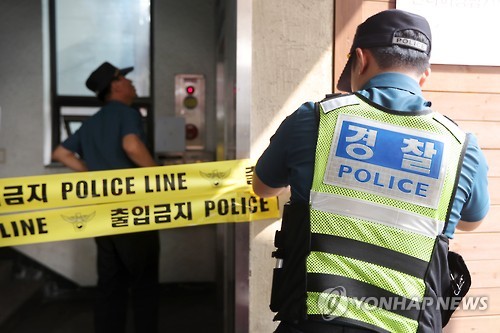 A police officer places yellow police tape in front of the office of renowned baseball commentator Ha Il-sung in Seoul on Sept. 8, 2016, after Ha, 67, was found dead there on the same day. The apparent suicide occurred just a few months after he was indicted over allegations of fraud.