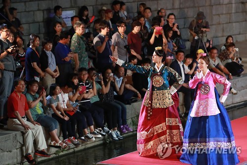 Female models walk on a stage set on Cheonggye Stream in downtown Seoul during a hanbok fashion show held on Sept. 10, 2016. 