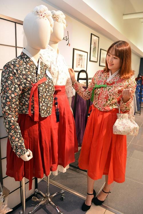 This undated photo provided by Daegu Department Store shows a woman checking out hanbok at a pop-up store in Daegu. 